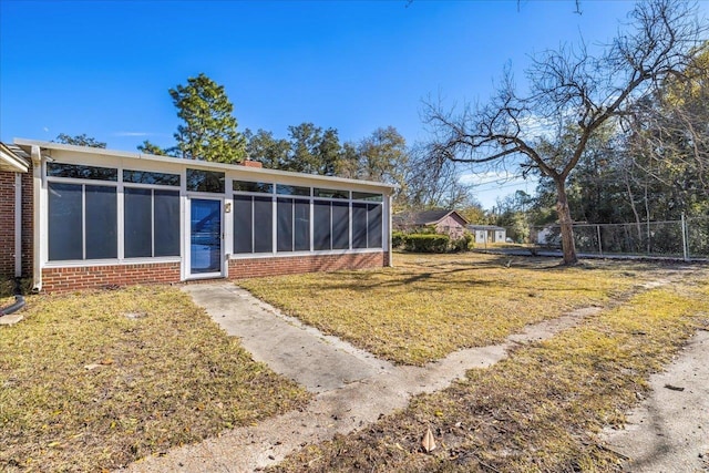 view of yard featuring fence and a sunroom