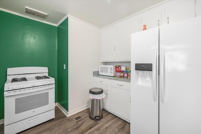 kitchen with visible vents, white cabinets, white appliances, and wood finished floors