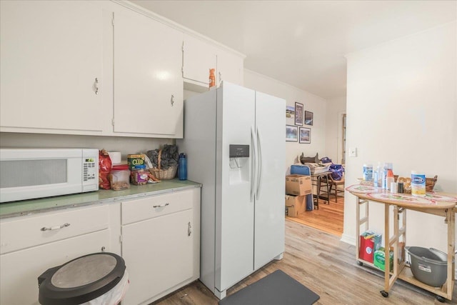 kitchen featuring light wood finished floors, white appliances, white cabinets, and light countertops