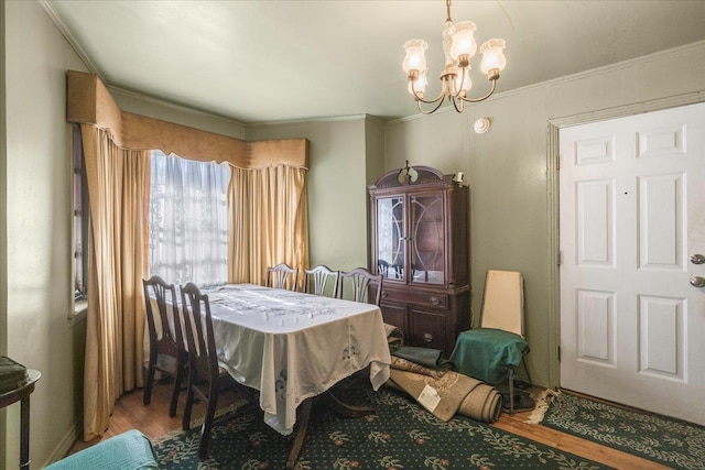 dining area featuring a chandelier, crown molding, and wood finished floors