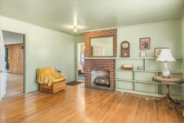 sitting room featuring ornamental molding, a fireplace, and wood finished floors