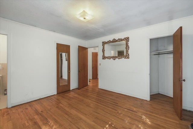 unfurnished bedroom with a closet and wood finished floors