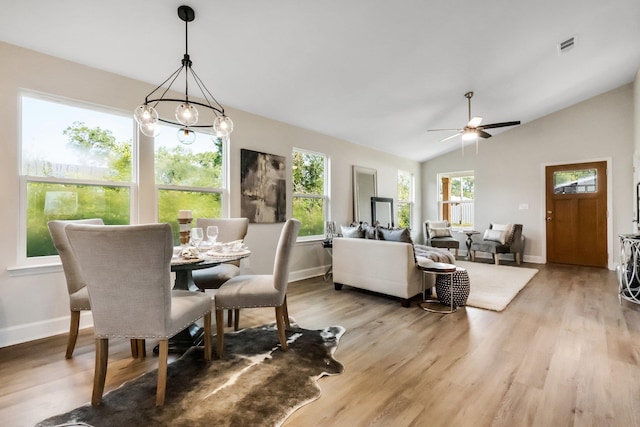 dining space featuring lofted ceiling, light wood-style flooring, visible vents, and baseboards