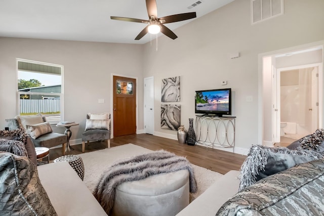 living area featuring baseboards, visible vents, and dark wood-style flooring