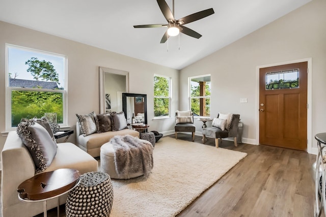 living area featuring light wood-type flooring, ceiling fan, baseboards, and vaulted ceiling