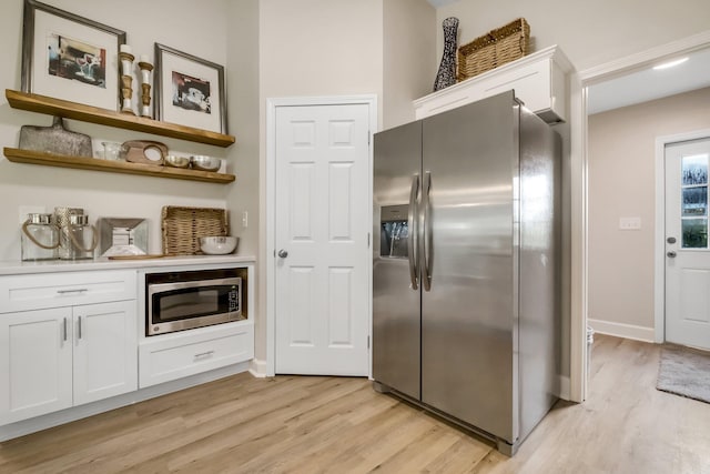 kitchen with white cabinets, open shelves, stainless steel appliances, and light countertops