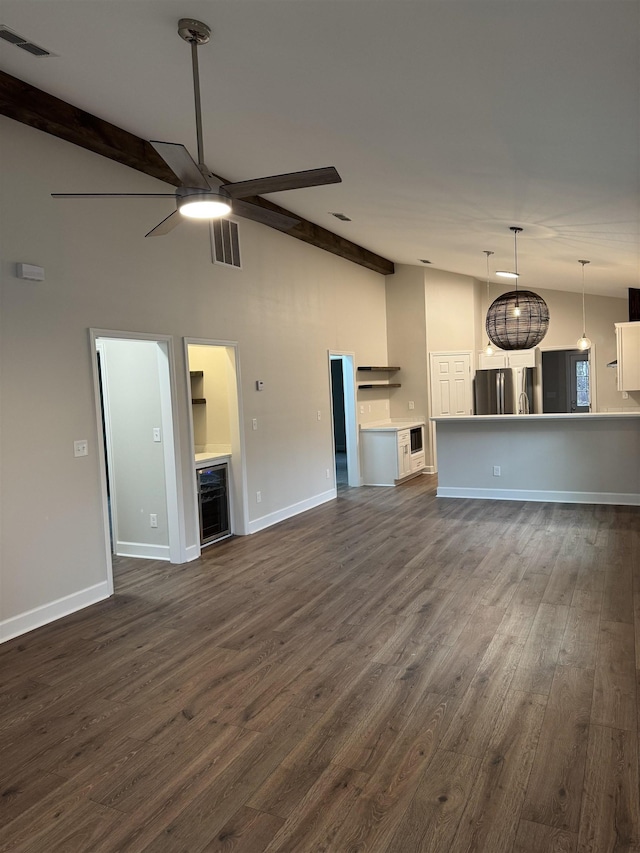 unfurnished living room with dark wood-style floors, vaulted ceiling with beams, visible vents, a ceiling fan, and baseboards