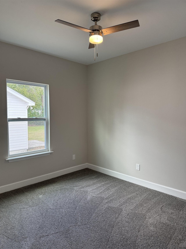 carpeted empty room featuring a ceiling fan and baseboards