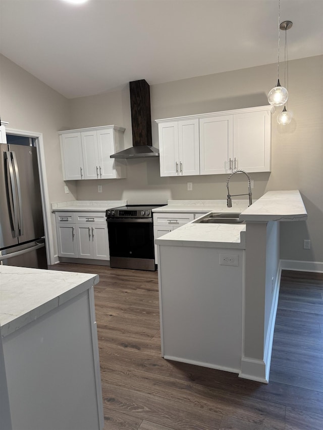 kitchen with light countertops, hanging light fixtures, appliances with stainless steel finishes, a sink, and wall chimney exhaust hood