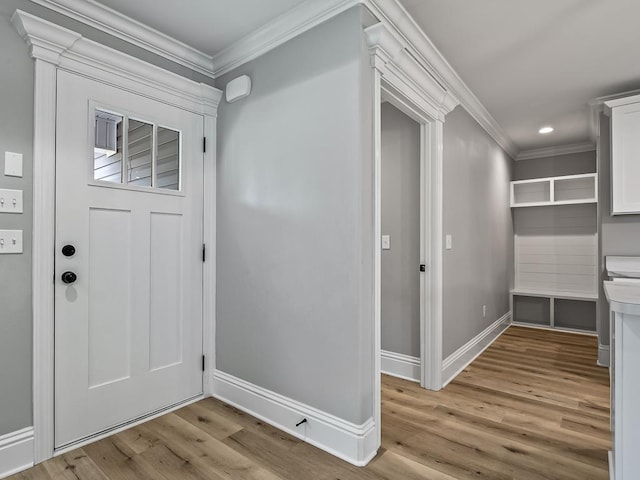 entryway with light wood-type flooring and crown molding