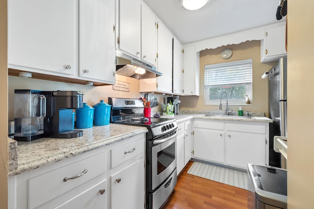 kitchen featuring stainless steel appliances, white cabinets, a sink, wood finished floors, and under cabinet range hood