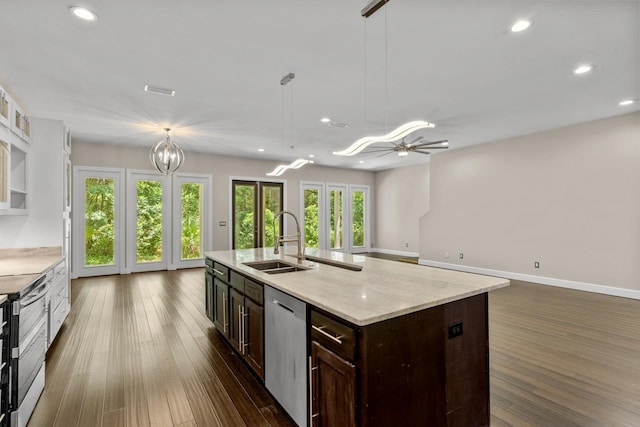 kitchen featuring stainless steel appliances, sink, a center island with sink, and decorative light fixtures