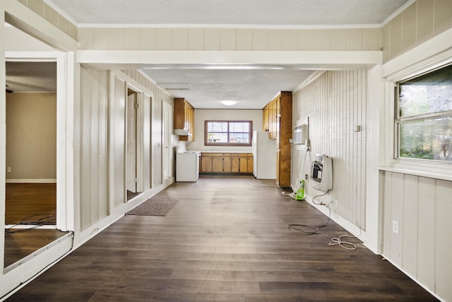 hall with crown molding, dark wood-type flooring, heating unit, and a textured ceiling