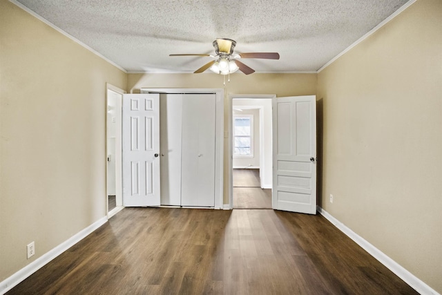 unfurnished bedroom with dark wood-type flooring, a closet, crown molding, and a textured ceiling