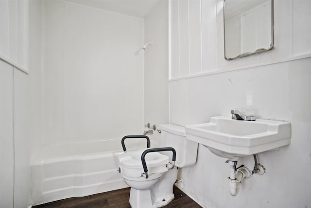 bathroom with tub / shower combination, hardwood / wood-style floors, and toilet