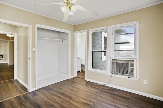 unfurnished bedroom featuring dark wood-type flooring, crown molding, a closet, cooling unit, and ceiling fan