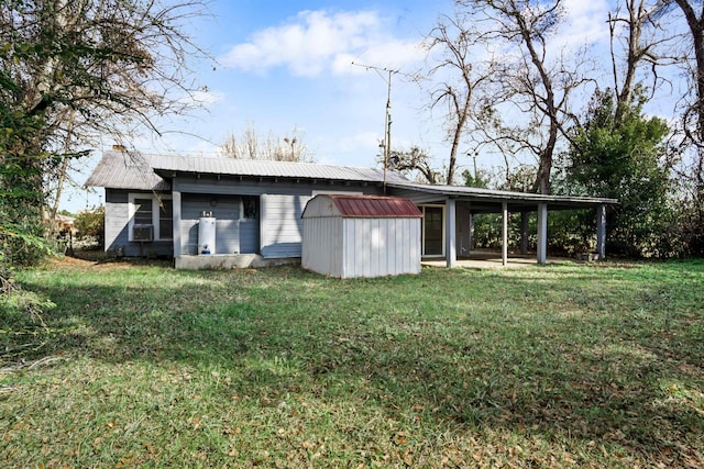 rear view of house featuring a lawn and a storage unit