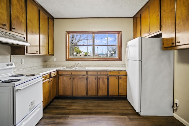 kitchen with sink, white appliances, dark wood-type flooring, and a textured ceiling