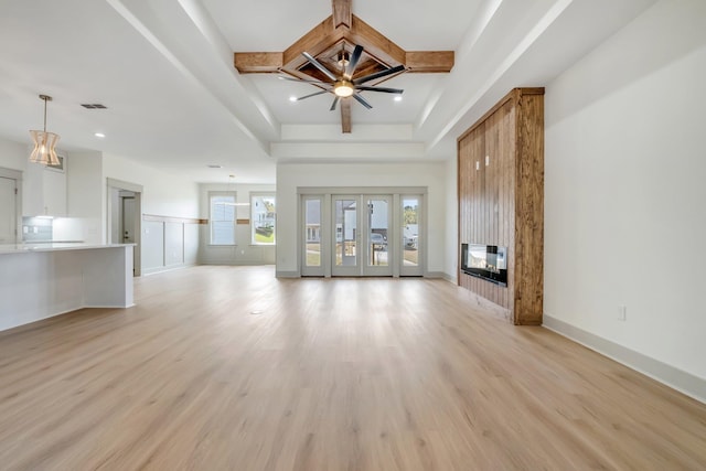 unfurnished living room with a multi sided fireplace, ceiling fan, and light hardwood / wood-style floors