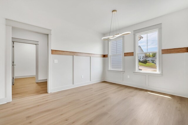 unfurnished dining area featuring light wood-type flooring