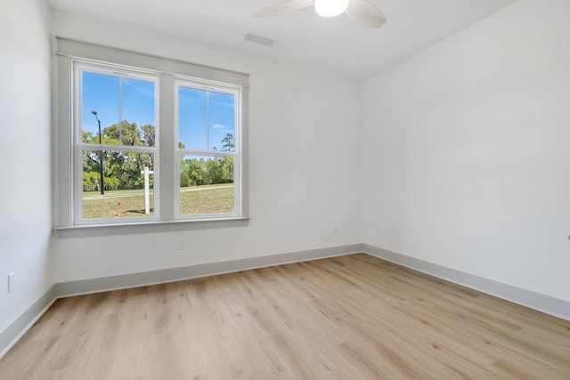 unfurnished room featuring ceiling fan, plenty of natural light, and light wood-type flooring