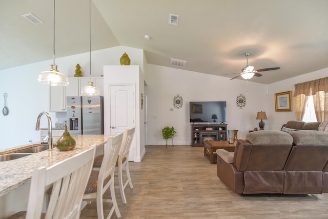 359 Mae Cato Dr, Midway, FL 32343 - living area featuring vaulted ceiling, a ceiling fan, light wood-style floors, and baseboards