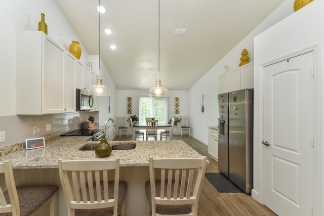359 Mae Cato Dr, Midway, FL 32343 - kitchen with stainless steel appliances, a sink, a peninsula, wood finished floors, and white cabinets