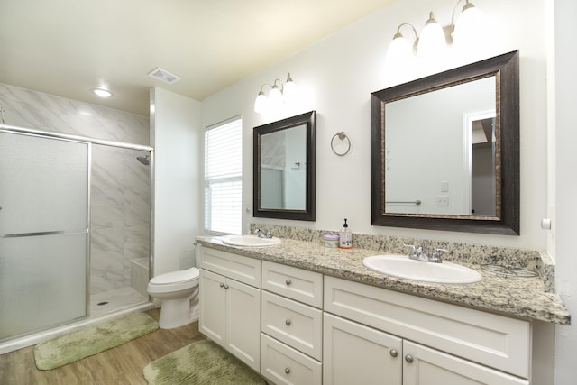 359 Mae Cato Dr, Midway, FL 32343 - full bath featuring wood finished floors, double vanity, a shower stall, and toilet