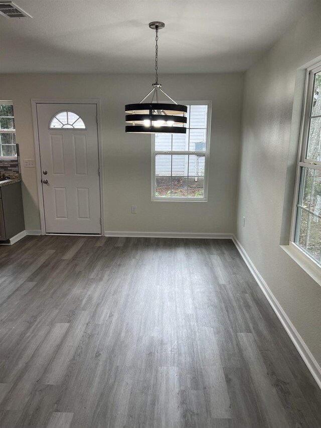 foyer entrance featuring baseboards, plenty of natural light, visible vents, and dark wood-type flooring