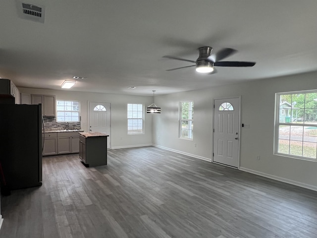 interior space featuring light countertops, dark wood-type flooring, a kitchen island, and freestanding refrigerator