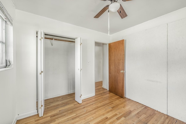 unfurnished bedroom with ceiling fan, a closet, and light wood-type flooring