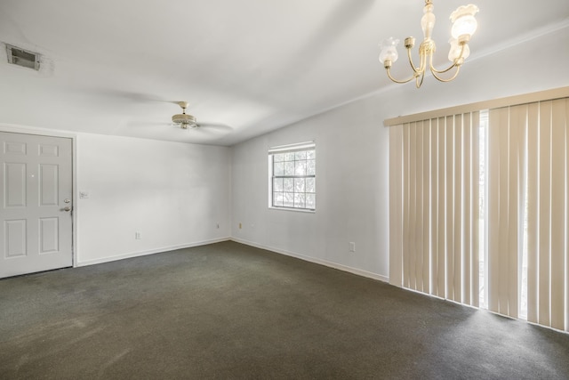 spare room with ceiling fan with notable chandelier, dark colored carpet, visible vents, and baseboards