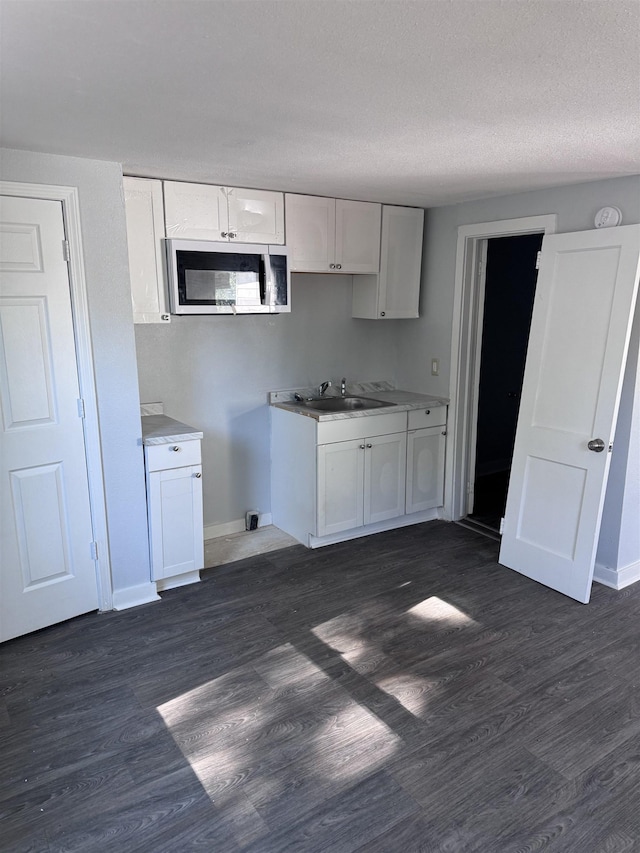 kitchen with white cabinetry, sink, and dark hardwood / wood-style flooring