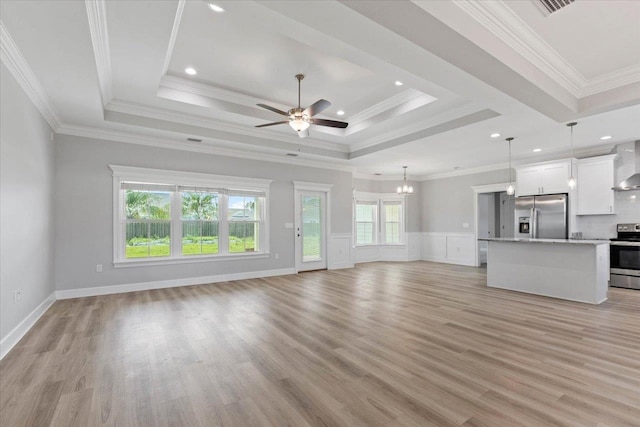 unfurnished living room with ornamental molding, ceiling fan with notable chandelier, and light hardwood / wood-style flooring