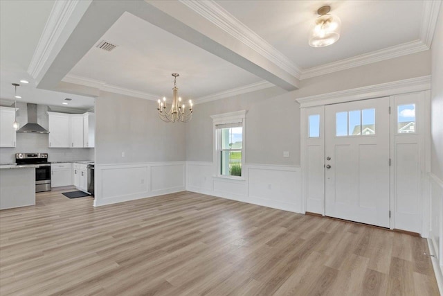 foyer entrance featuring light hardwood / wood-style floors, a chandelier, and crown molding