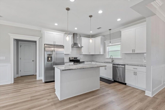 kitchen featuring stainless steel appliances, a kitchen island, pendant lighting, white cabinets, and wall chimney exhaust hood