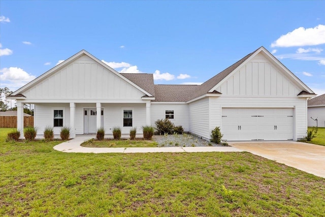 view of front of house featuring a garage, a front yard, and a porch