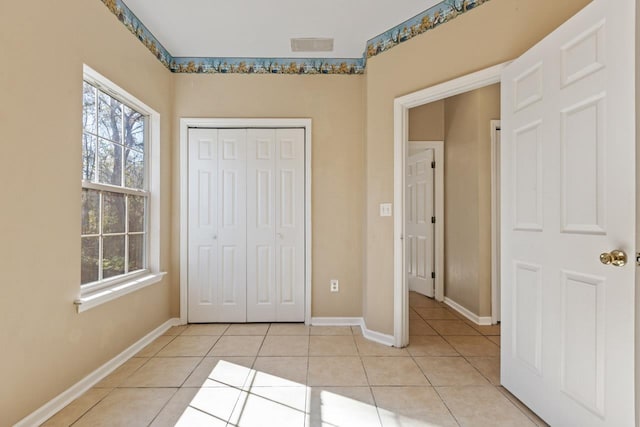 unfurnished bedroom featuring light tile patterned floors and a closet