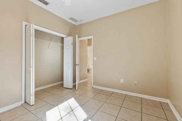 unfurnished bedroom with light tile patterned floors and a closet