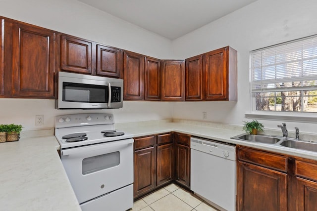 kitchen with sink, white appliances, and light tile patterned flooring