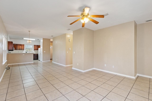 unfurnished living room with light tile patterned floors and ceiling fan with notable chandelier