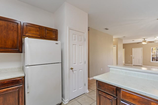 kitchen featuring light tile patterned flooring, white fridge, and ceiling fan