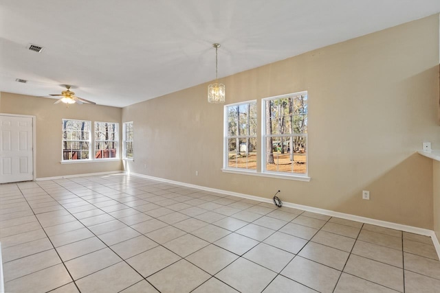 tiled empty room featuring ceiling fan with notable chandelier