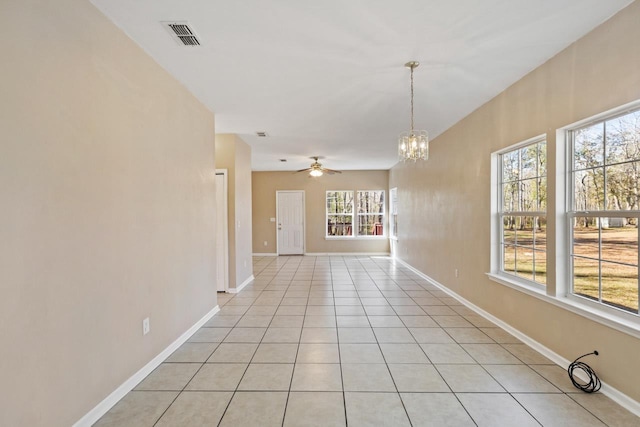 spare room featuring ceiling fan with notable chandelier and light tile patterned flooring