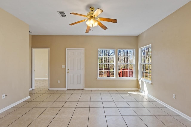 tiled spare room with ceiling fan