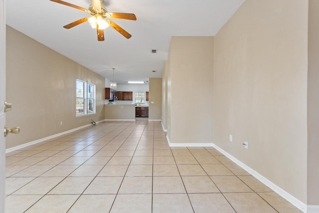 unfurnished living room featuring light tile patterned floors and ceiling fan