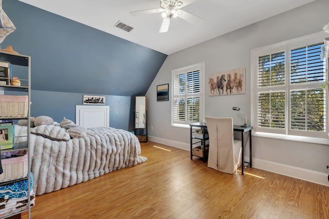 bedroom featuring lofted ceiling, visible vents, light wood-style floors, ceiling fan, and baseboards