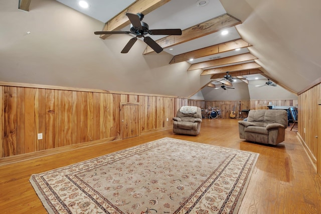 bonus room featuring light wood-style floors, wainscoting, lofted ceiling with beams, and wooden walls