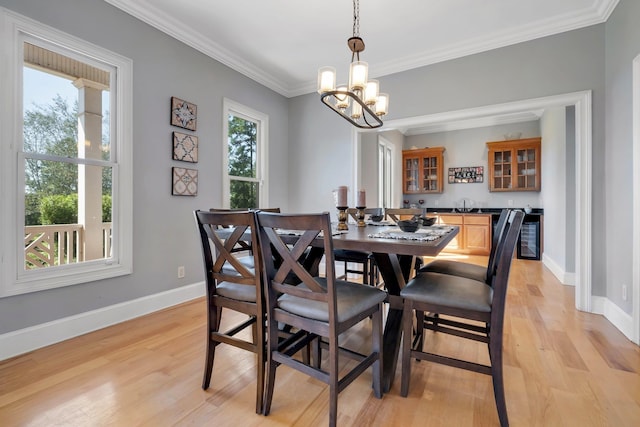 dining area with crown molding, baseboards, plenty of natural light, and light wood finished floors