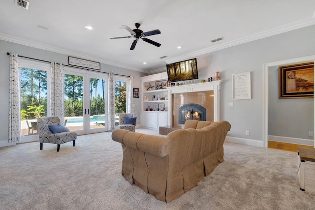 living room featuring ornamental molding, french doors, a premium fireplace, and visible vents